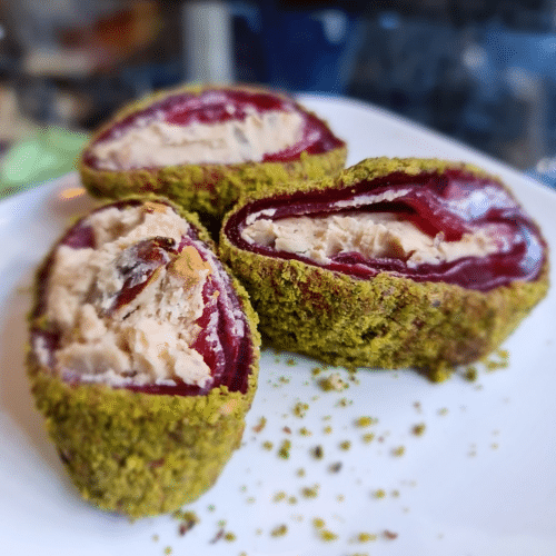 met gepoederde pistachenoten en granaatappel-amandelcrème erin